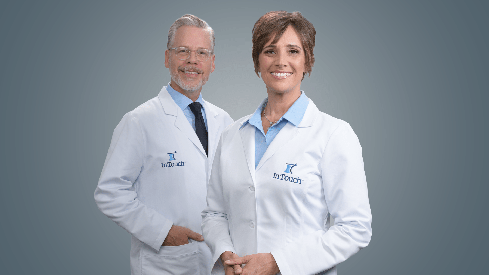 In Touch Pharmaceuticals brand photography. Two pharmacists standing side-by-side. One male, one female.